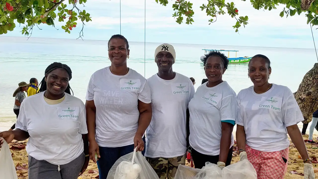 Sunset at the Palms Green Team members participating in a coastal cleanup along Negril's shoreline.