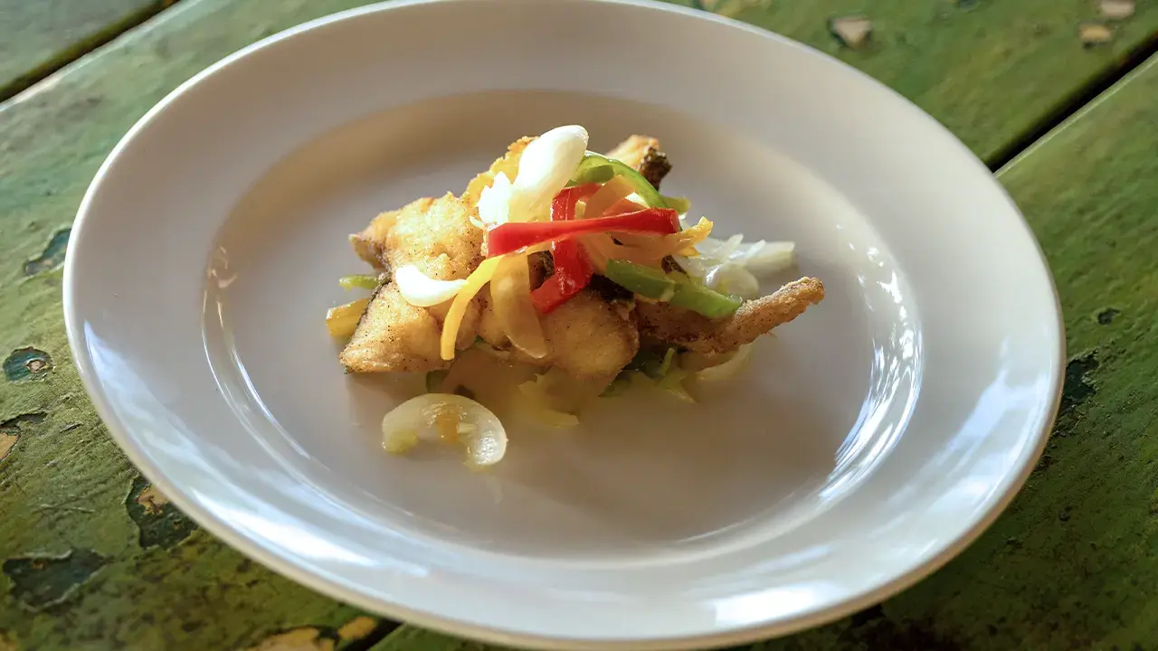 Alt text: Ackee and saltfish plated with peppers and onions at Sunset at the Palms.